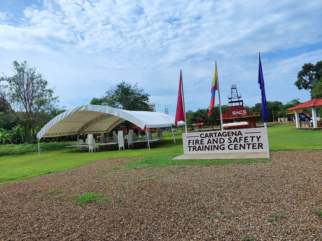 Carpa tipo hangar instalada para evento corporativo al aire libre, con banderas y estructura cubierta para atención de público.